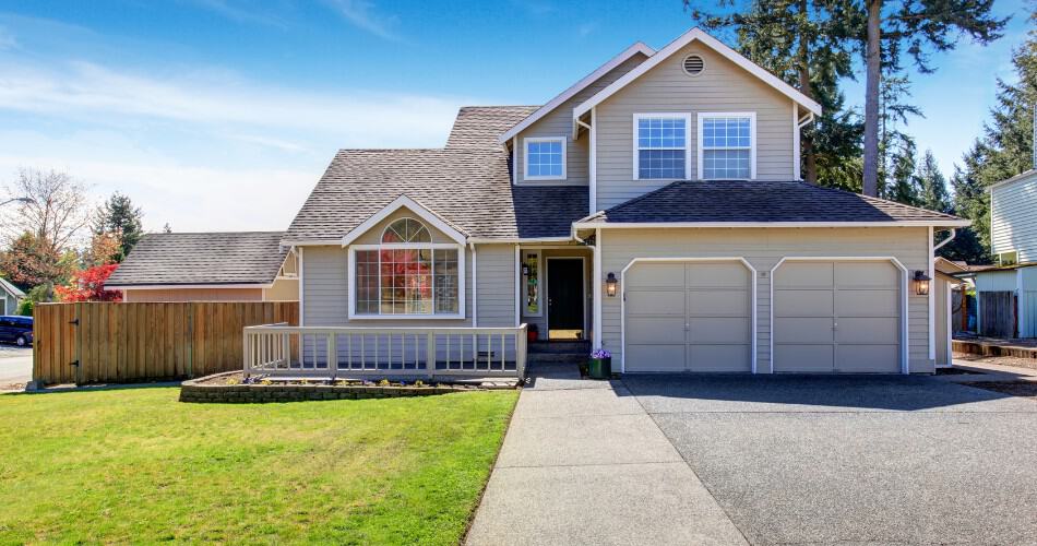 Jacksonville Florida Concrete. A charming home featuring a garage and a well-maintained driveway, showcasing a welcoming exterior.